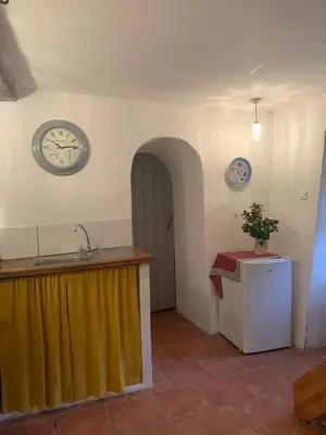 a kitchen with a sink and a clock on the wall at Havre de paix in Mas-Cabardès