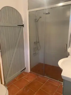 a shower with a glass door in a bathroom at Havre de paix in Mas-Cabardès
