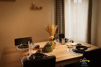 a dining room table with chairs and a wooden table with at Superbe Nid Douillet avec Terrasse, Double Parking in Carcassonne