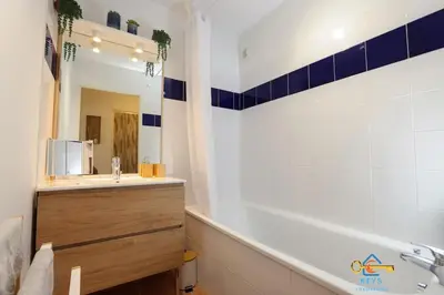 a bathroom with a tub and a sink and a mirror at Superbe Nid Douillet avec Terrasse, Double Parking in Carcassonne