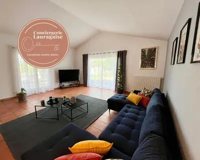 a living room with a blue couch and a table at Villa Louis - calme et spacieuse avec vue in Castelnaudary
