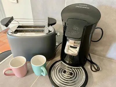 a coffee maker and two cups on a counter at Villa Louis - calme et spacieuse avec vue in Castelnaudary
