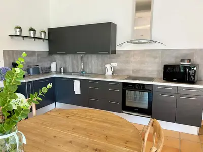 a kitchen with a wooden table in a kitchen at Villa Louis - calme et spacieuse avec vue in Castelnaudary