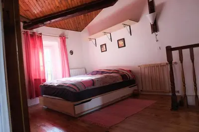 a bedroom with a bed in a room with red curtains at Charmante Maison de Village dans les fenouilledes in Cassagnes