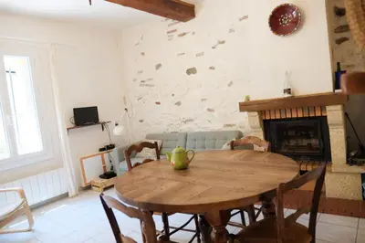 a wooden table in a living room with a fireplace at Charmante Maison de Village dans les fenouilledes in Cassagnes