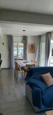 a living room with a table and a blue couch at Villa Bellevue in Roquefort-des-Corbières