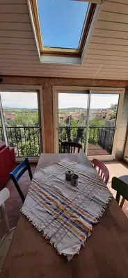 a table in a room with a large window at Villa Bellevue in Roquefort-des-Corbières