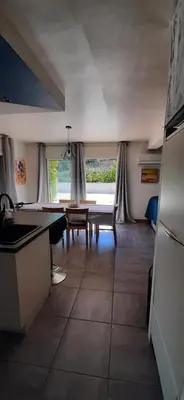 a kitchen with a table and a dining room at Villa Bellevue in Roquefort-des-Corbières