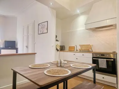 a kitchen with a wooden table with four plates on it at Appartement Centre Ville Les Halles - Grands Buffets in Narbonne