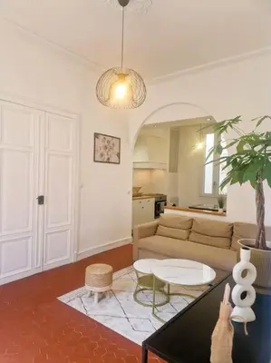 a living room with a couch and a table at Appartement Centre Ville Les Halles - Grands Buffets in Narbonne