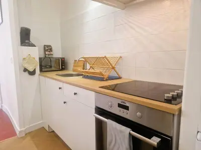 a kitchen with a stove and a counter top at Appartement Centre Ville Les Halles - Grands Buffets in Narbonne