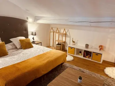 a bedroom with a large bed with a yellow blanket at LE PAOLO Appartement Deluxe in Narbonne