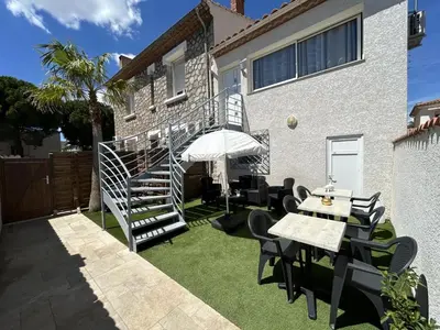 a patio with a table and chairs and a staircase at LE PAOLO Appartement Deluxe in Narbonne