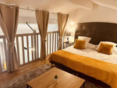 a bedroom with a large bed and a balcony at LE PAOLO Appartement Deluxe in Narbonne