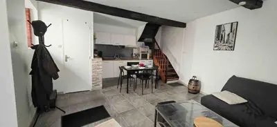 a kitchen and a living room with a couch and a table at Maison Puylaurentaise in Puylaurens