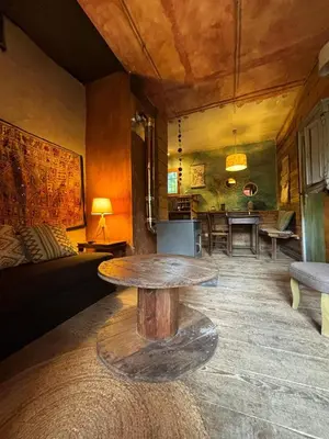 a living room with a table and a couch at Le Jardin in Rennes-les-Bains