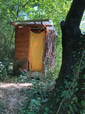 a out house with a yellow door in a tree at Le Jardin in Rennes-les-Bains