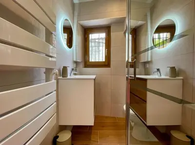 a bathroom with two sinks and two mirrors at La Tour de Guet in Carcassonne