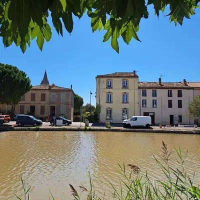 a body of water in front of buildings at La Maison du Canal - Homps - Le Sweet in Homps
