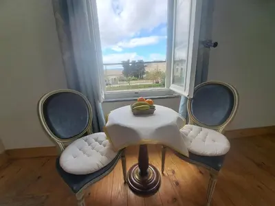 a table with a bowl of fruit on it in front of a window at La Maison du Canal - Homps - Le Sweet in Homps