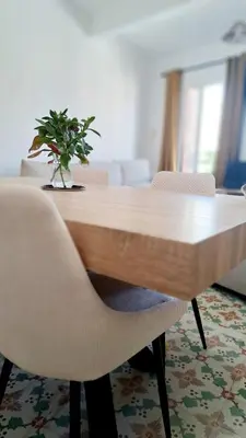 a wooden table with chairs and a vase with a plant at Casa Tramuntana in Tautavel