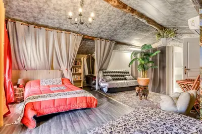 a bedroom with a bed and a couch at Le Chardonneret Élégant - Maison pour 4 climatisée in La Livinière