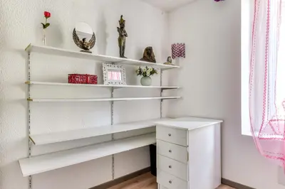 a room with white shelves and a desk at Le Chardonneret Élégant - Maison pour 4 climatisée in La Livinière
