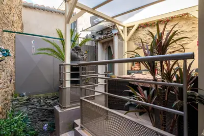 a courtyard with plants and a fence at Le Chardonneret Élégant - Maison pour 4 climatisée in La Livinière