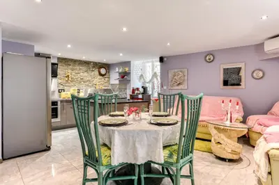 a dining room and living room with a table and chairs at Le Chardonneret Élégant - Maison pour 4 climatisée in La Livinière