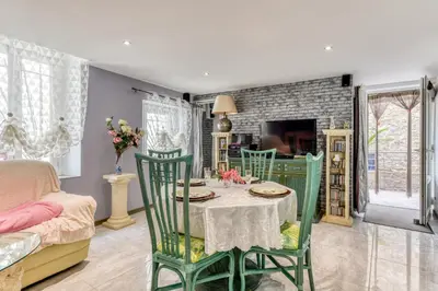 a dining room with a table and four chairs at Le Chardonneret Élégant - Maison pour 4 climatisée in La Livinière