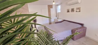 a bed in a room with a plant at Maison à louer in Narbonne