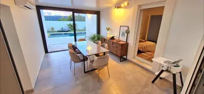 a dining room with a table and chairs and a bedroom at Maison à louer in Narbonne