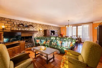 a kitchen with a table and a white refrigerator at L'Oustal 3 chambres avec grand jardin parking gratuit in Bram