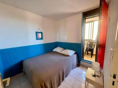 a bedroom with a bed and a window and a chair at Duplex T4 Confort 6 Pers., Piscine, Parking, Centre Port à Gruissan - FR-1-796-74 in Gruissan