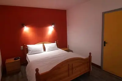 a bedroom with a large bed with a red wall at Terrasse avec vue-Spa-Clim sur les 2 niveaux-Famille-Vacances-Week-end in Preixan
