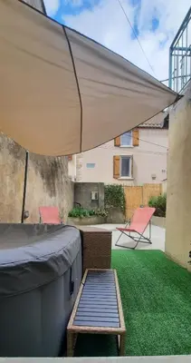 a patio with a large umbrella and a table and chairs at Terrasse avec vue-Spa-Clim sur les 2 niveaux-Famille-Vacances-Week-end in Preixan