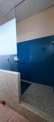 a bathroom with a shower with a blue wall at Terrasse avec vue-Spa-Clim sur les 2 niveaux-Famille-Vacances-Week-end in Preixan