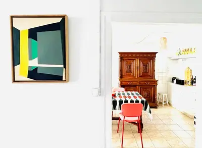 a living room with a table and a red chair at Maison de campagne Arty entièrement rénovée 4 chambres in Roquecourbe