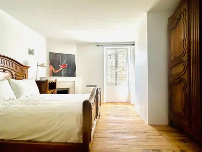a bedroom with a bed and a desk and a window at Maison de campagne Arty entièrement rénovée 4 chambres in Roquecourbe
