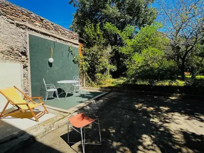 a patio with a table and chairs next to a building at Maison de campagne Arty entièrement rénovée 4 chambres in Roquecourbe