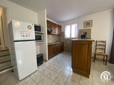 a kitchen with a white refrigerator and a counter at Grenache rdc in Fosse