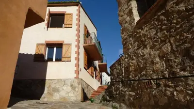 a building with two windows and a stone wall at Grenache rdc in Fosse