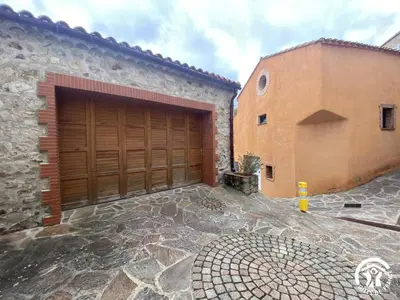 a garage with a wooden door next to a building at Grenache rdc in Fosse