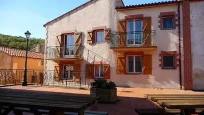 a building with a table and benches in front of it at Grenache rdc in Fosse