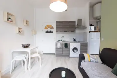 a living room with a couch and a table and a kitchen at Le 107 CARCA ! in Carcassonne