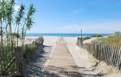 a wooden path to the beach with the ocean in the background at Lovely Home In Saint Laurent De La Ca in Saint-Laurent-de-la-Cabrerisse