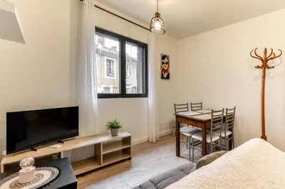 a living room with a tv and a table at Le Logis de Joseph au pied de la Cité Médiévale in Carcassonne