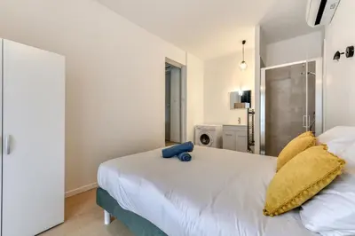 a bedroom with a white bed with yellow pillows at Le Logis de Joseph au pied de la Cité Médiévale in Carcassonne