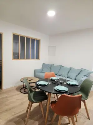 a living room with a table and a couch at Le Maillot IV in Castres