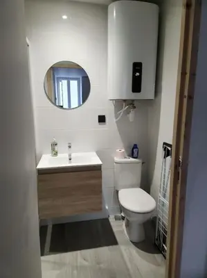 a bathroom with a toilet and a sink and a mirror at Le Maillot IV in Castres
